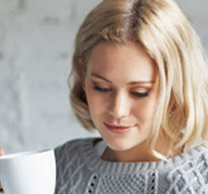 Blonde woman holding white coffee mug
