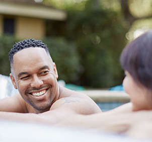 Man smiling at woman in pool