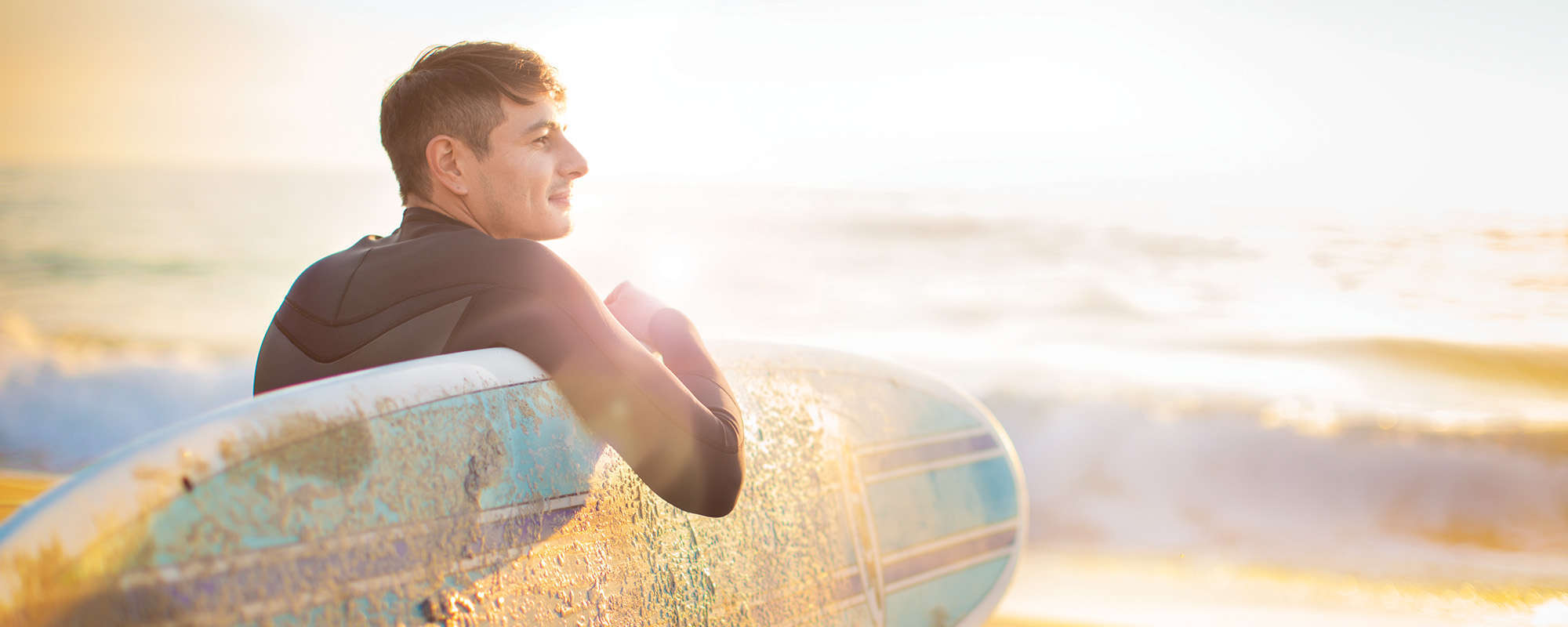 Background Image 1.1.1 A Man entering ocean with surfboard