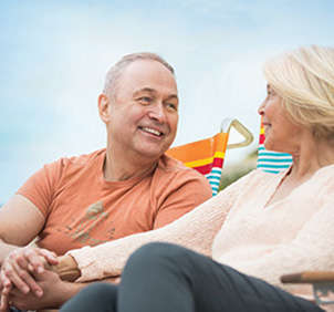 Older couple sitting on beach chairs